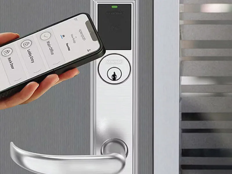 Close-up of a hand using a smartphone to open a door using security system integration.