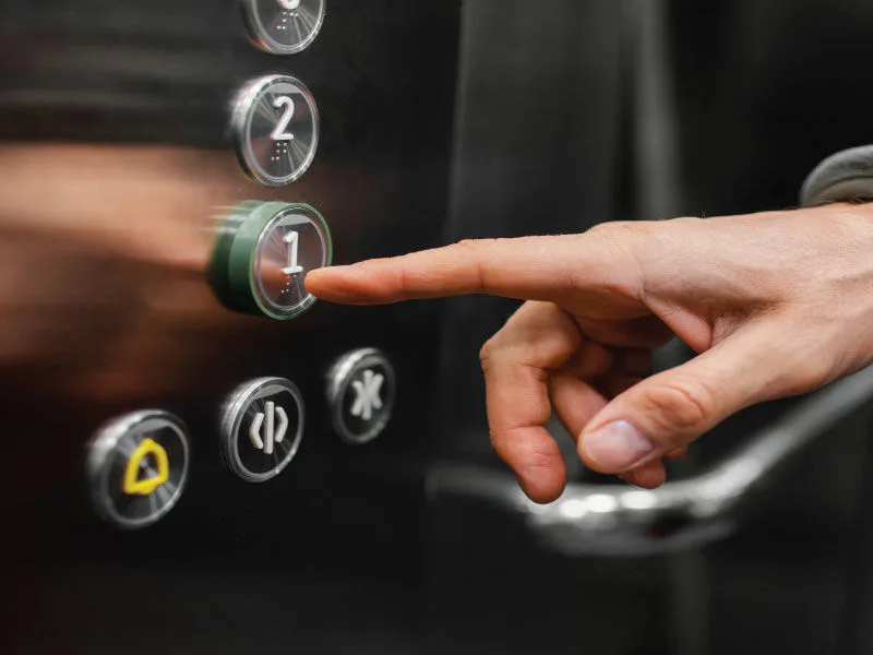 Close-up of a finger using an elevator an integrated security system.