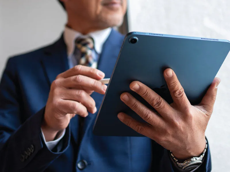 Close-up of a man controlling integrated security system through and ipad