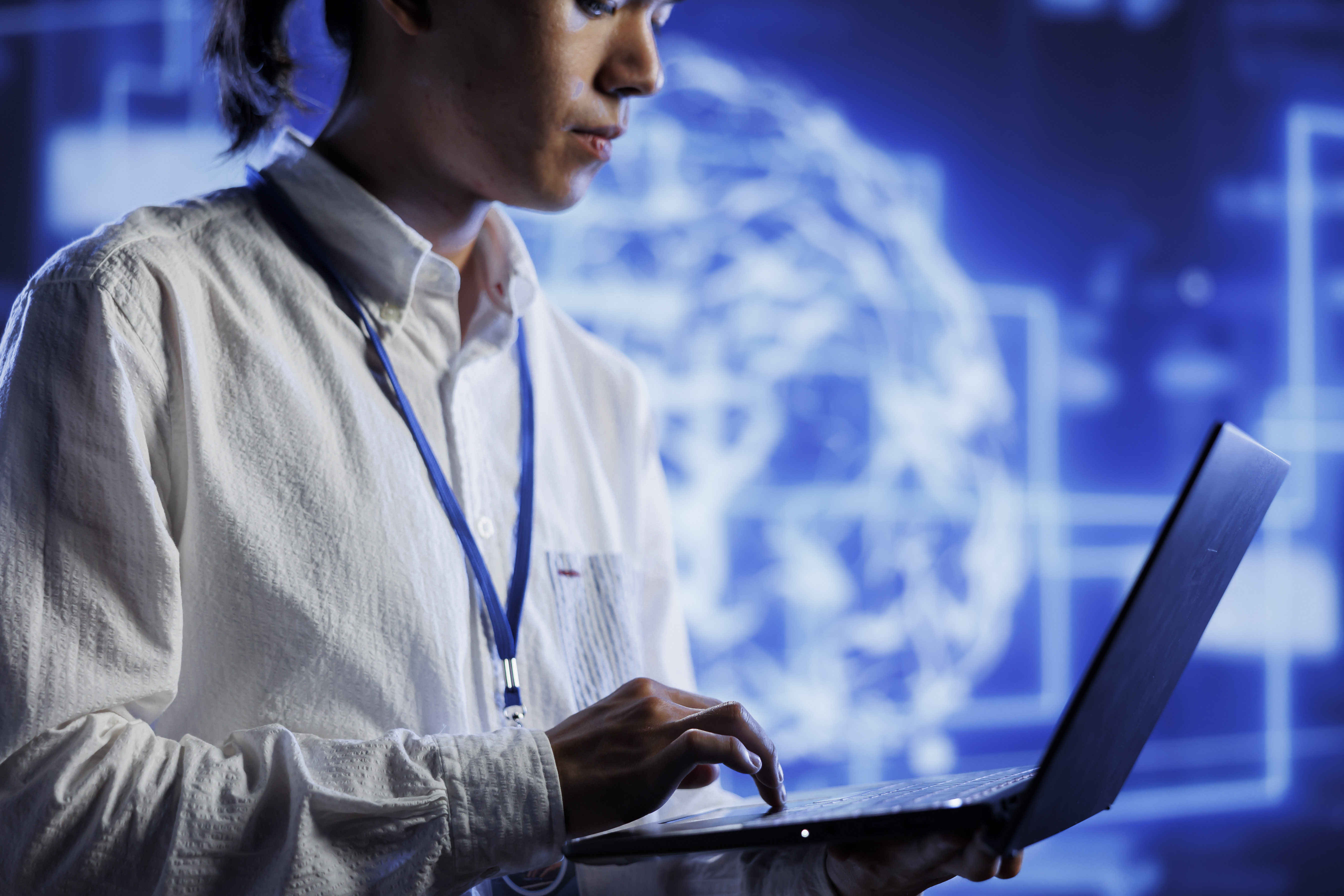 Technology professional reviewing AI systems on a laptop to find cost reduction and automation opportunities