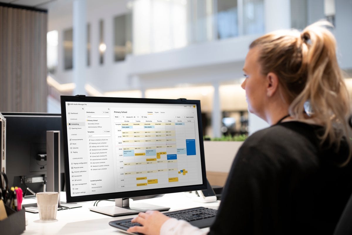 Staff member viewing an AXIS Audio Manager Pro schedule on a desktop monitor