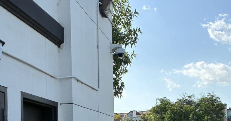 Axis dome camera covering a rear service door at a commercial property in Los Angeles County