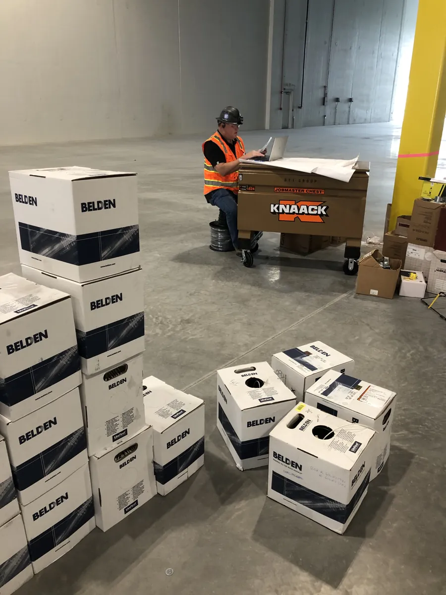 BTI technician unboxing and staging network and IT equipment in a new client warehouse in Palatine, Illinois
