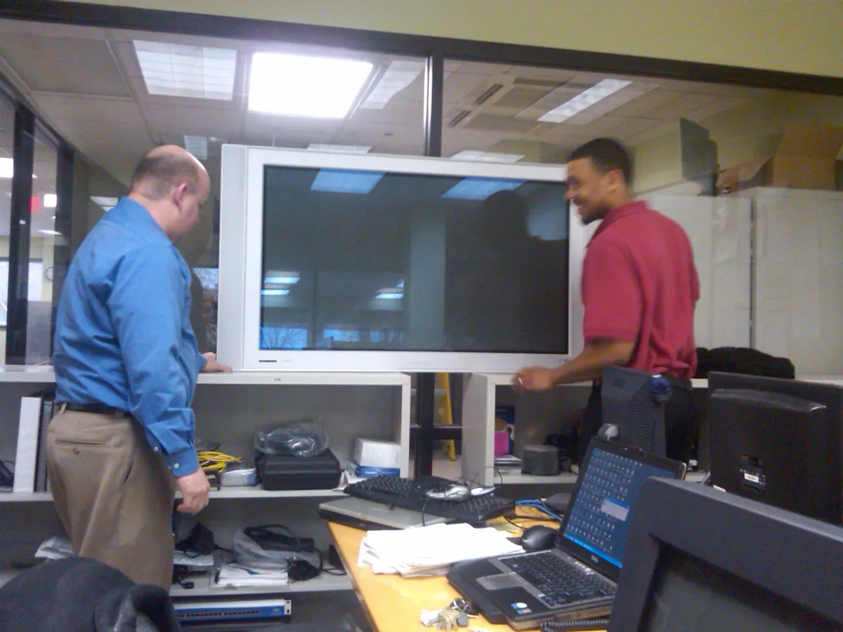 Historical photo from 2000: Nick Sherrill and Donald Hampton installing a screen in BTI's original Network Monitoring Operations Center, 500 W. Madison, 21st floor, Chicago